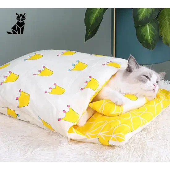 Chat se relaxant sur un lit douillet en coton avec un oreiller jaune et blanc