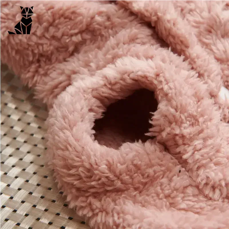 Mignon ourson rose sur un lit à côté de Sweat-shirt en polaire pour chiens, parfait pour la protection hivernale des animaux de compagnie